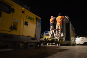 Two NPE commissioning crew install the emergency pumping equipment at night.